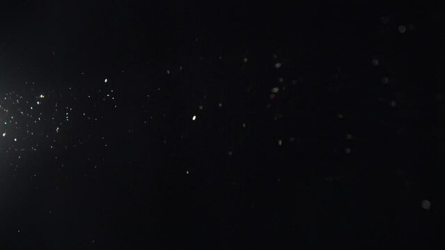 ein Lichtstrahl im Dunklen, man sieht den Staub fliegen