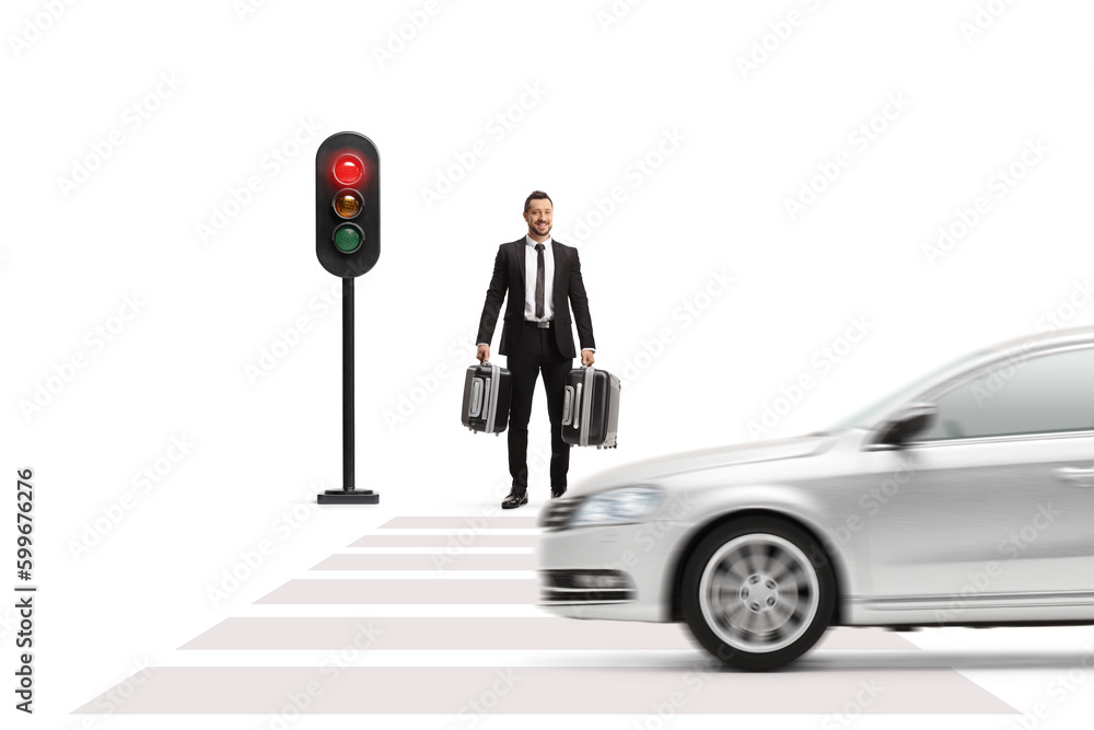 Wall mural Businessman carrying suitcases and waiting at traffic lights