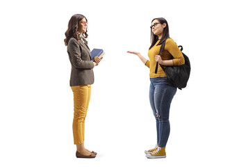Full length profile shot of a female student talking to a female holding books