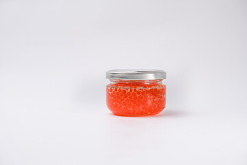 Bank of red trout caviar on a white background.