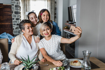 latin Multi Generation women Family Posing For photo Selfie at dinner time At Home Together in Latin America