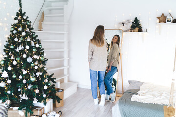 Young woman admiring herself in mirror during Christmas holidays