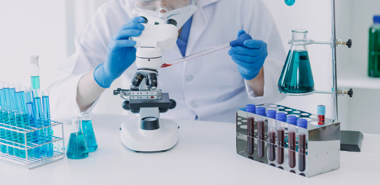 microscope with lab glassware, science laboratory research and development concept