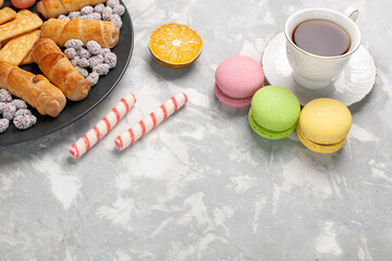 top view yummy cakes with crackers french macarons and cup of tea on grey-white desk cake biscuit cookie sugar sweet pie