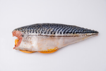 Raw mackerel stuffed with lemon and spices on a white background.
