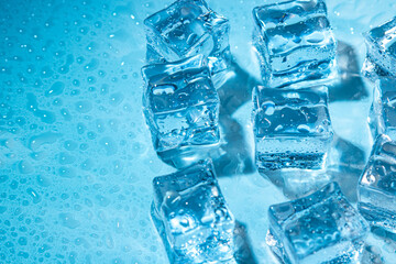 Wet ice cubes on a blue background.