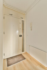 an empty room with white walls and wood flooring the door is open on the right side of the room