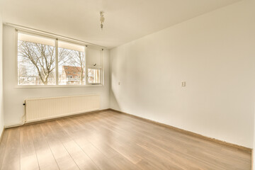 an empty room with wood flooring and white paint on the walls, there is a window in the corner