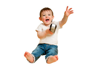 Toddler baby plays with a wireless music speaker on a studio isolated on a white background. Happy child in a white t-shirt listens to music in an audio speaker. Kid aged one year four months