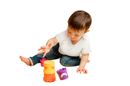 Toddler baby is playing logical educational games with a sandbox mold on a studio isolated on a white background. Happy child playing with an educational toy bucket. Kid aged one year four months