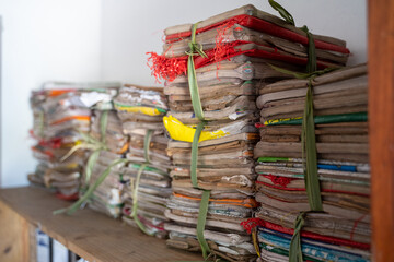 Alte, abgenutzte Schulbücher und Schulhefte liegen gestapelt und zusammengeschnürt in einer...