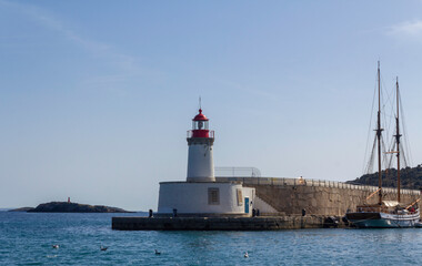 The picturesque Ibiza lighthouse surrounded by water, sky, and seagulls