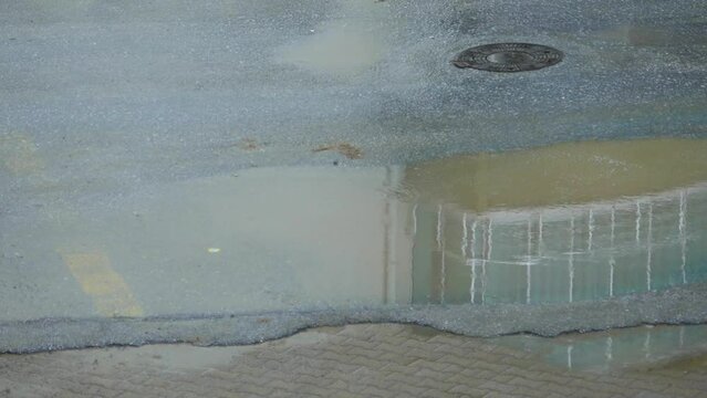puddles on city pavements and roads after rain, unplanned urbanization,