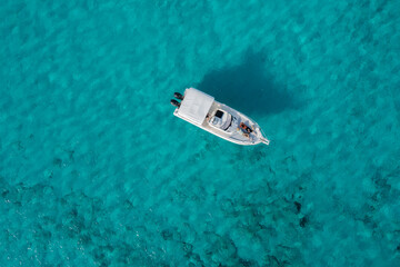 A yacht floating on the beautiful blue waters of Formentera, with a couple lying down and resting on board.