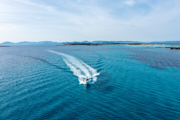 A yacht gliding through the beautiful blue waters of Formentera, with a couple on board enjoying the motion