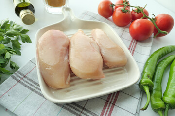  raw breast chicken meat on a plate on white background