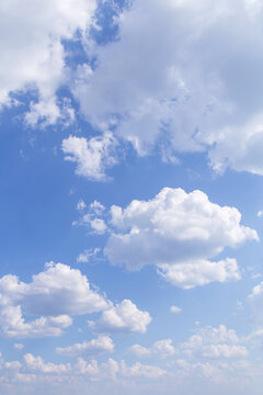 Beautiful epic soft gentle blue sky with white fluffy clouds in sunlight background texture