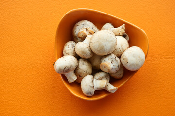 Fresh champignons mushroom in a white bowl on table 