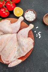 top view fresh raw chicken with red tomatoes and greens on a dark background cooking butcher dish food meat salad barbecue color dinner