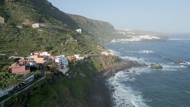 survol des pentes raides des montagne d'une îles des Canaries et un de ses villages de maisons blanches