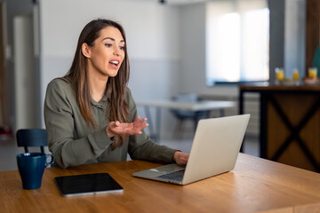 Confident young businesswoman employee, HR manager having remote online work hybrid meeting or distance job interview, gesturing with hands during virtual video conference call in home office.