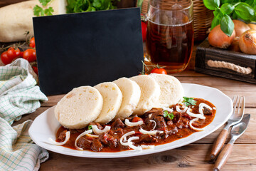 The perfect goulash prepared according to a classic recipe. Traditional Czech Goulash meal with dumplings. Place for text - obrazy, fototapety, plakaty