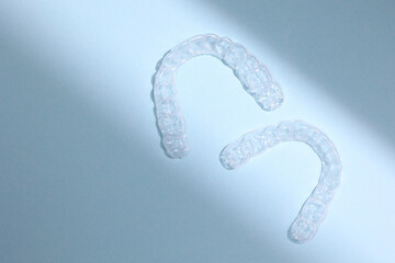 Transparent plastic dental aligners on a colored background
