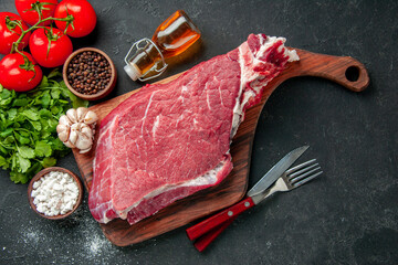 top view raw meat slice with tomatoes seasonings and greens on dark background cooking color food meat barbecue meal butcher