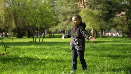 Two little sisters are walking on a green lawn