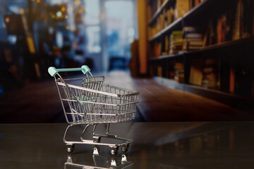 Empty shopping cart in out-of-focus bookstore background