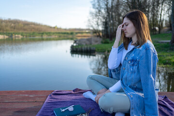 Woman practices pranayama in lotus pose outdoors