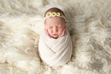 photo of a baby sleeping on a white blanket. Newborn baby girl - authentic newborn photography session in a white clean studio