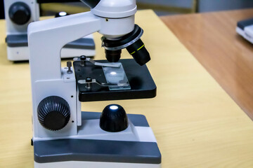 Old vintage microscope on table sepia photo