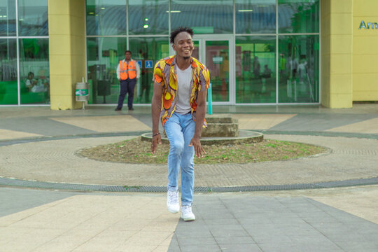 Joven Afrodescendiente baila al estilo urbano en el centro de la ciudad usando atuendos coloridos