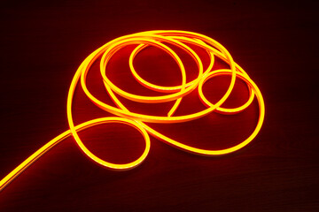 Flexible neon is lying on the table. Neon orange light for the production of outdoor...