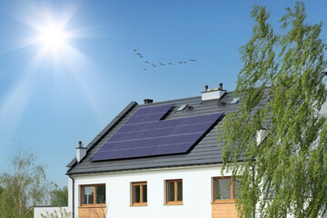 White house with solar panels, sun and cloudless sky