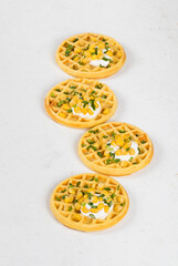 Round corn waffles with soft cottage cheese and greens. White background