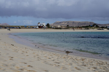 Fototapeta na wymiar White sand, blue water and stormy clouds on La Concha beach, El Cotillo surfers village, Fuerteventura, Canary islands, Spain