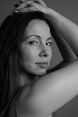 Black and white portrait of a woman without makeup. Natural female portrait with first wrinkles and plump lips