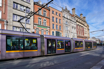 Fototapeta na wymiar Modern Dublin tram train heading towards Parliament House on College Street