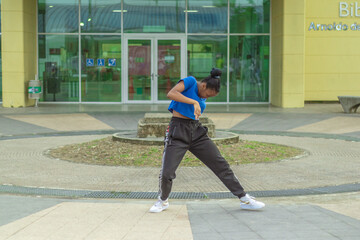 Fototapeta na wymiar Joven Afro baila al estilo urbano en el centro de la ciudad