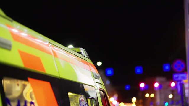 Quick Action: Ambulance with Flashing Lights Near a Shopping Center at Night