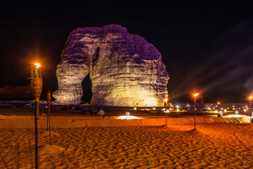 Illuminated by burning torches sandstone elephant rock erosion monolith standing in the night...