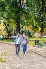 Obraz premium Gay male couple walking holding hands outdoors