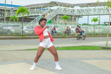 Fototapeta premium Joven Afro baila al estilo urbano en el centro de la ciudad