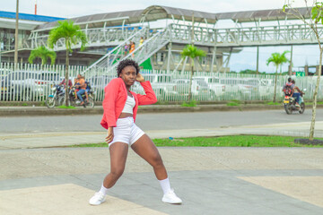 Obraz premium Joven Afro baila al estilo urbano en el centro de la ciudad