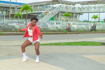 Fototapeta premium Joven Afro baila al estilo urbano en el centro de la ciudad