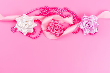 a top view designed roses colored along with pink necklace on the pink desk color composition flower