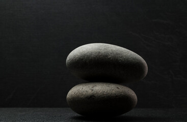 gray zen stones on a dark gray background with shadows for a podium background.a group of oval stones for product presentation