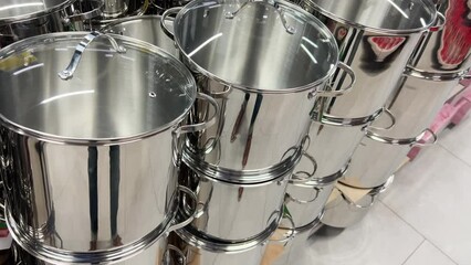 Metallic shiny pans on the shelves of a cookware store